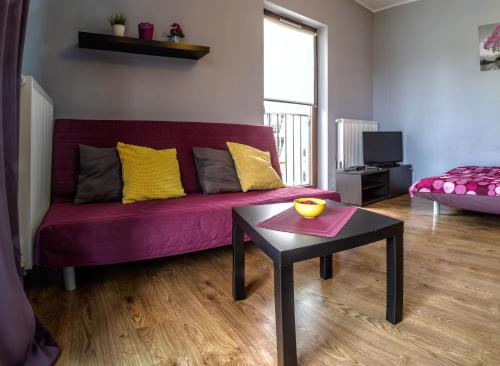ヴロツワフにあるMarea Apartmentの紫色のソファとテーブル付きのリビングルーム