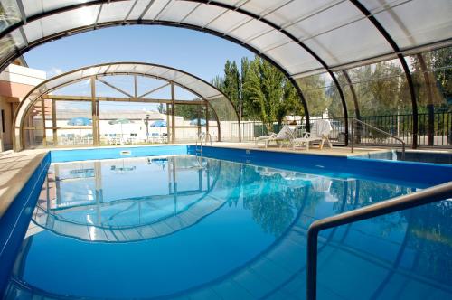 a swimming pool with an arched ceiling and blue water at Land Express Neuquén in Neuquén