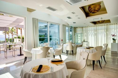 a restaurant with white tables and chairs and windows at Damianii Luxury Boutique Hotel & Spa in Omiš