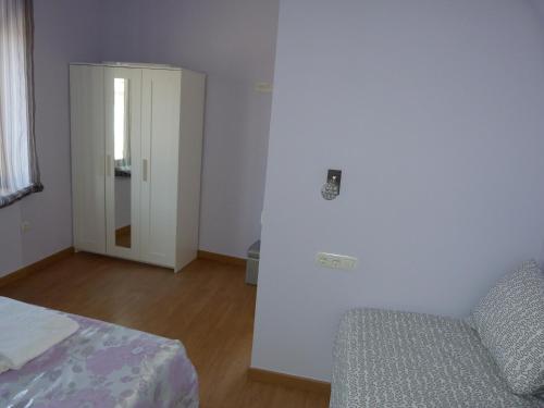 1 dormitorio con 1 cama, 1 silla y 1 puerta en Apartamento Zapatero en Trabanca