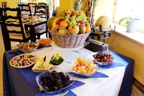 a table with a basket of fruit and other snacks at Les Reflets Jaunes in Givet
