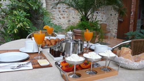 a table with a tray of food and glasses of orange juice at ma chambre d'hôtes à Rivesaltes in Rivesaltes