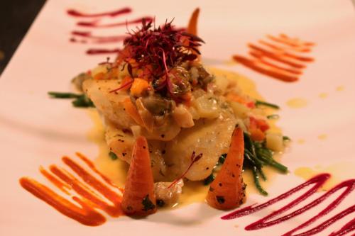 a white plate with a piece of food with carrots at The Gower Hotel in Swansea