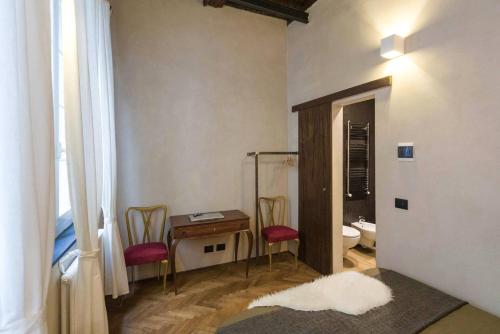 a bathroom with a table and chairs and a toilet at Charming Genova | Residenza d'epoca in Genova