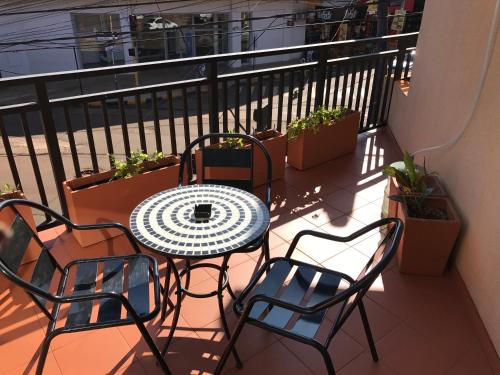 d'une table et de chaises sur un balcon orné de plantes. dans l'établissement Flora Apartments, à Puerto Iguazú