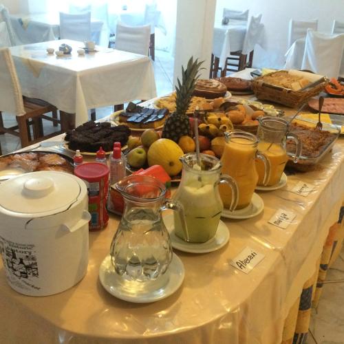 a table with a buffet of fruit and juice at Hotel Luz do Sol in Balneário Camboriú