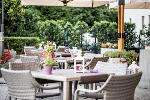 an outdoor patio with chairs and tables and an umbrella at Mercure Genova San Biagio in Genova