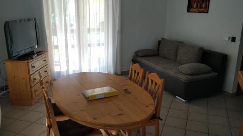a living room with a wooden table and a couch at Anna villa in Lenti