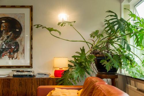 a living room with plants and a couch and a lamp at Pension Homeland in Amsterdam