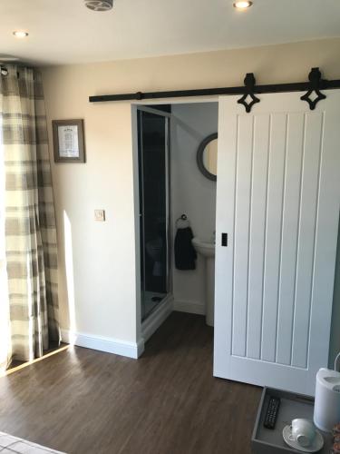 a room with a sliding door and a bathroom at The Half Moon Inn in Goole