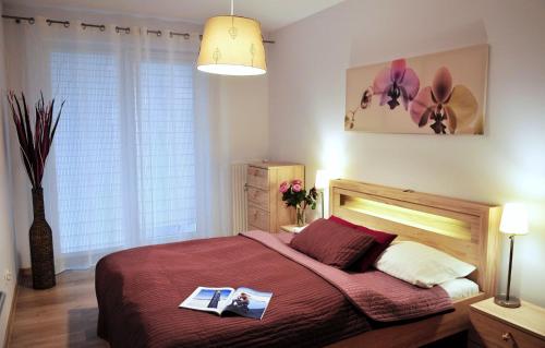 a bedroom with a bed with two magazines on it at Polanki Sea Kolberg in Kołobrzeg