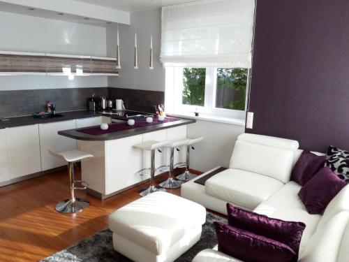a living room with a white couch and a kitchen at Marcelo Deluxe Apartment in Tihany