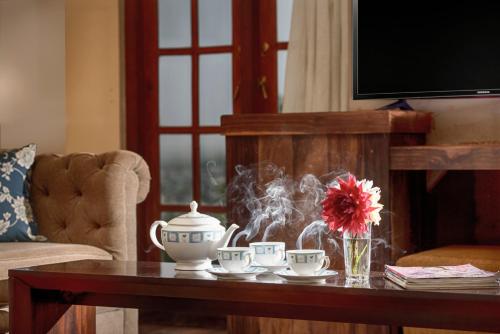 a living room with a coffee table with tea cups at Villa Lemon Court in Nuwara Eliya