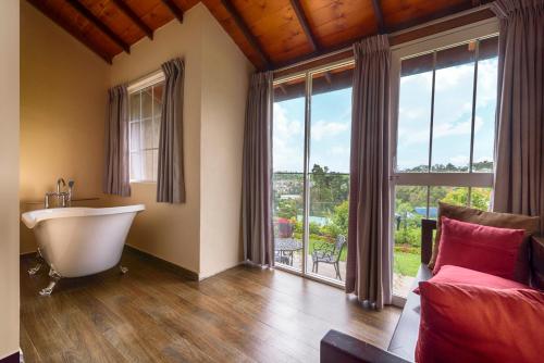a bathroom with a tub and a large window at Villa Lemon Court in Nuwara Eliya