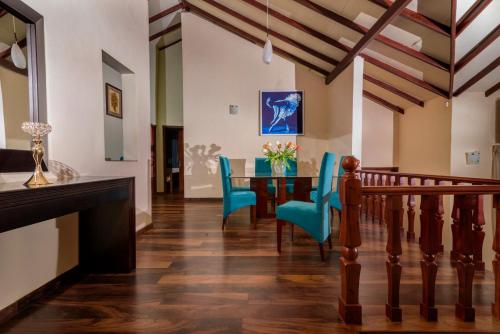 a dining room with a table and blue chairs at Villa Lemon Court in Nuwara Eliya