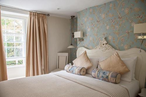 a bedroom with a bed with pillows on it at The Wychwood Inn in Shipton under Wychwood