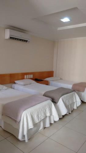 a group of beds in a room at Hotel Sao Miguel in Colatina