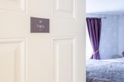 a bedroom with a bed and a sign on the wall at The Wychwood Inn in Shipton under Wychwood