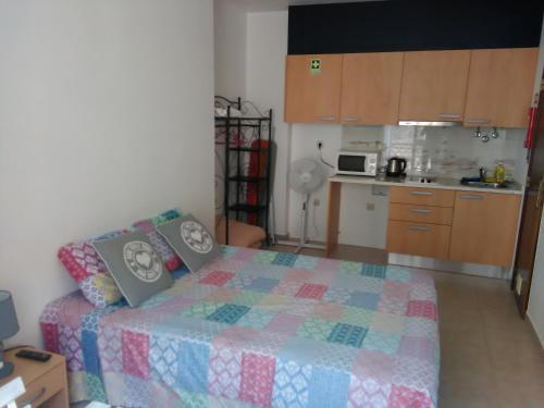 a small bedroom with a bed and a kitchen at Casa Eloy in Setúbal