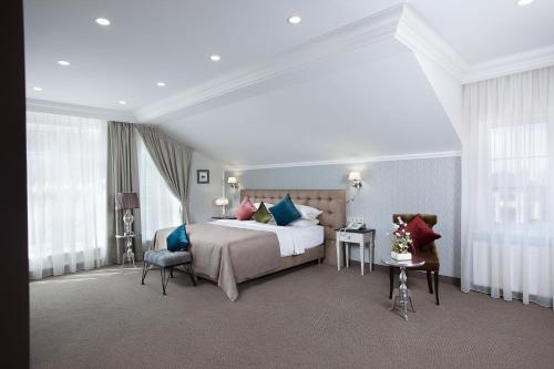 um quarto de hotel com uma cama, cadeiras e janelas em ДОНСКОЙ em Rostov on Don