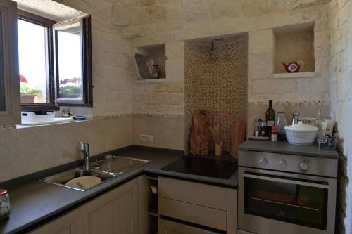 Il comprend une cuisine équipée d'un évier et d'une cuisinière. dans l'établissement Truly Trulli, à Alberobello