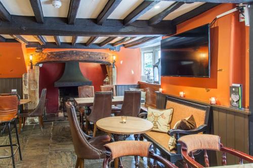 a pub with a table and chairs and a fireplace at The Wychwood Inn in Shipton under Wychwood
