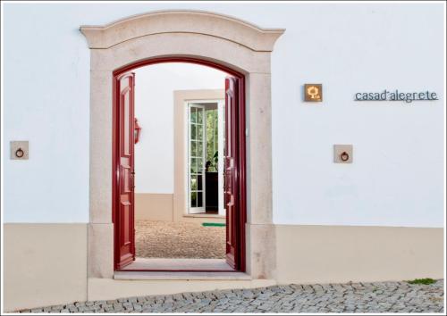 una entrada a un edificio con una puerta roja en Casa d´Alegrete, en Alegrete