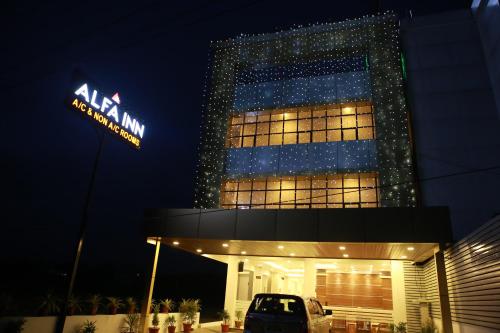 a lit up building with aania sign in front of it at Alfa Inn in Nedumbassery
