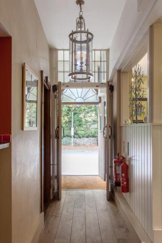 a hallway with a door and a chandelier at The Wychwood Inn in Shipton under Wychwood