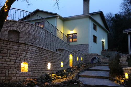 a house with a brick wall with lights on it at Thea Dodoni in Manteio