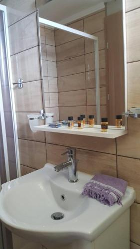 a bathroom with a sink and a mirror at Petani Beachside Accommodation in Vóvikes