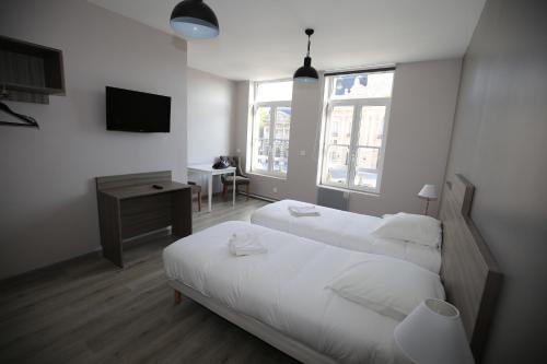 um quarto de hotel com duas camas e uma televisão em L'Hotel De France em Roubaix