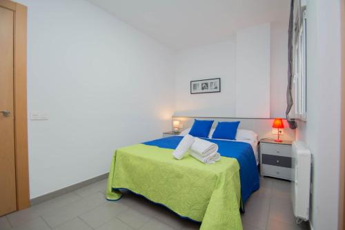 グラナダにあるEnjoyGranada GRAN VIA 1B & Parking opcionalのベッドルーム(青いベッド1台、緑のテーブル付)
