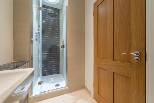 ウィンザーにあるHampden Apartments - The Elizabethのバスルーム(シャワー付)、木製のドアが備わります。