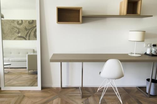 a table and a white chair in a room at Ca' Barbini Resort in Garda