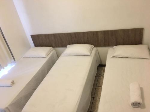 two beds sitting next to each other in a room at Hotel Luz do Sol in Balneário Camboriú