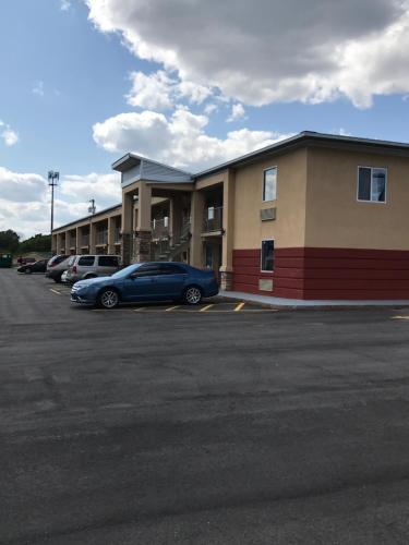 a blue car parked in a parking lot in front of a building at Lotus Inn and Suites Nashville in Nashville