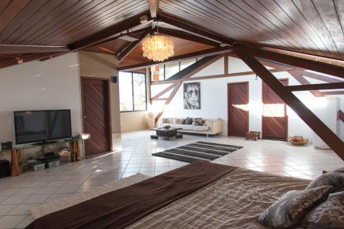 a large room with a bed and a tv at Casa Colina Pipa in Pipa