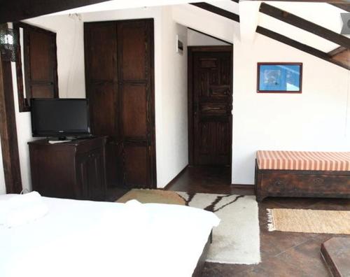 sala de estar con TV y 2 puertas en Villa Jovan, en Ohrid