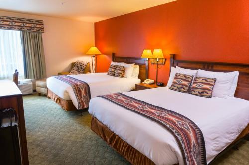 two beds in a hotel room with orange walls at Hualapai Lodge in Peach Springs