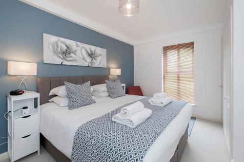 a bedroom with a bed with two towels on it at Liberty Suite Apartment in Portishead