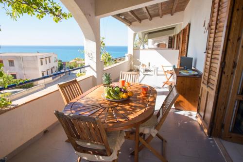 a table with a bowl of fruit on a balcony at Residence Capo San Marco & Renella in Sciacca
