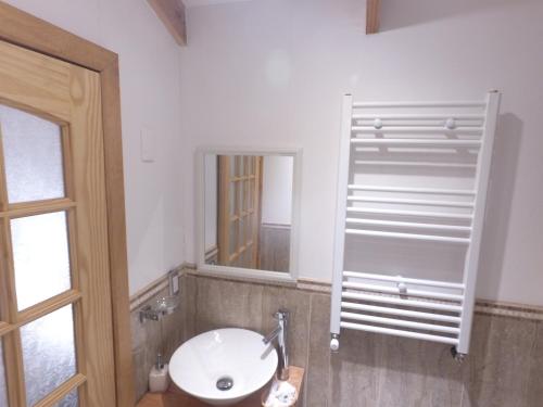 a bathroom with a white sink and a mirror at Hostal Fernando de Magalhaes in Punta Arenas