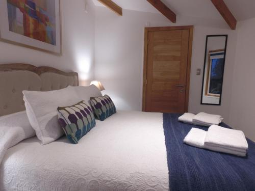 a bedroom with a bed with two towels on it at Hostal Fernando de Magalhaes in Punta Arenas