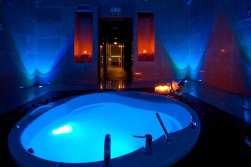 a jacuzzi tub in a room with blue lights at Style Hotel in Milan