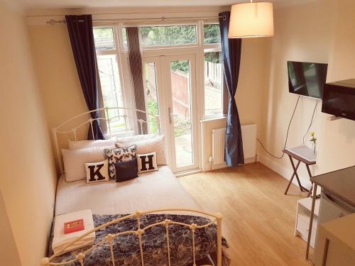 a bedroom with a bed and a large window at Kathleen House Plus in Enfield