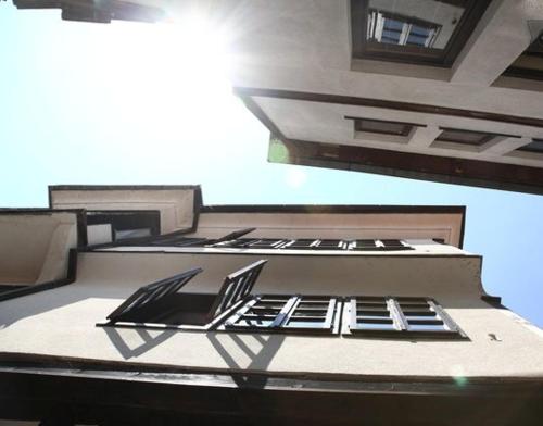 a building with four chairs on the side of it at Villa Jovan in Ohrid