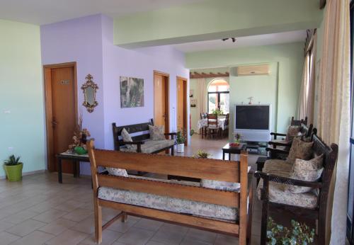 a living room with a couch and a tv at Lofos Hotel in Plakias