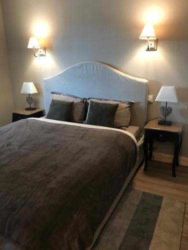a bedroom with a large bed with two night stands at Les Maisons du Périgord in Terrasson-Lavilledieu