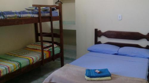 a room with two bunk beds and a blue bag on a table at Pousada Moporã, a antiga pousada do Waldir, com amplas suítes no centro de Aiuruoca in Aiuruoca